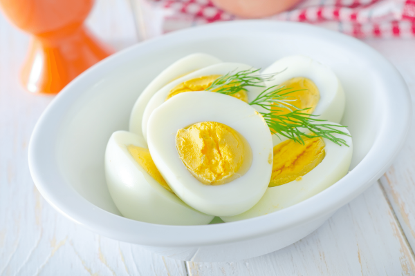 Hard boiled eggs cut in half in white bowl