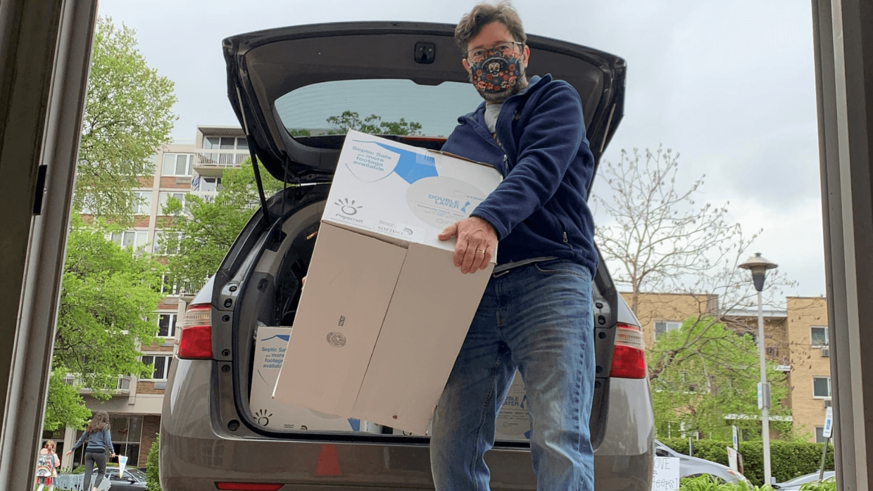 Michael Swaine with case of toilet paper delivery to the donation window at Beyond Hunger