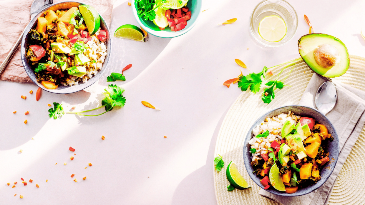 Healthy meal with avocados and cilantro, limes and lemons on the table and a table setting