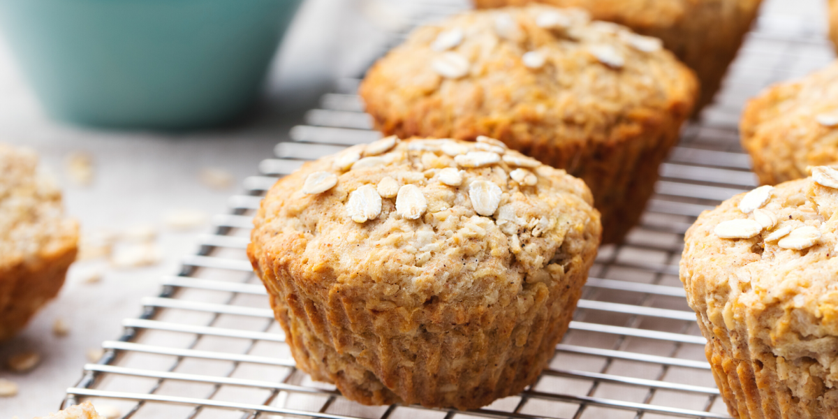 Photo of Apple Oatmeal Muffins on a metal cooling rack, with a blue bowl in the background.