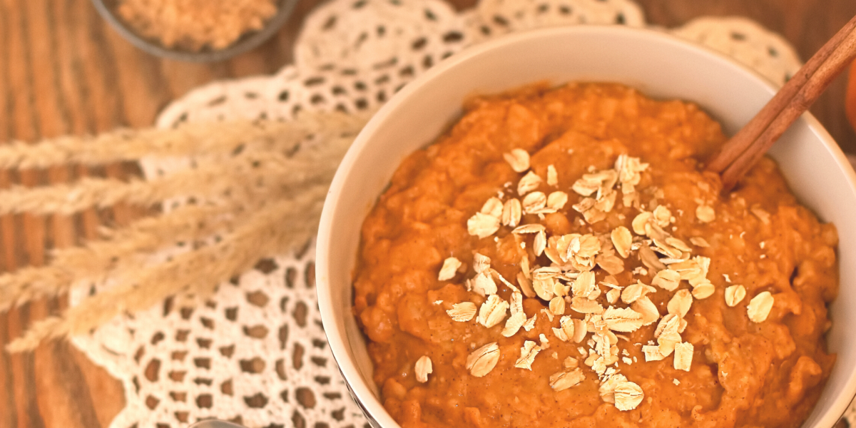 Photo of Baked Pumpkin Oatmeal in a white bowl, against an autumn themed background.