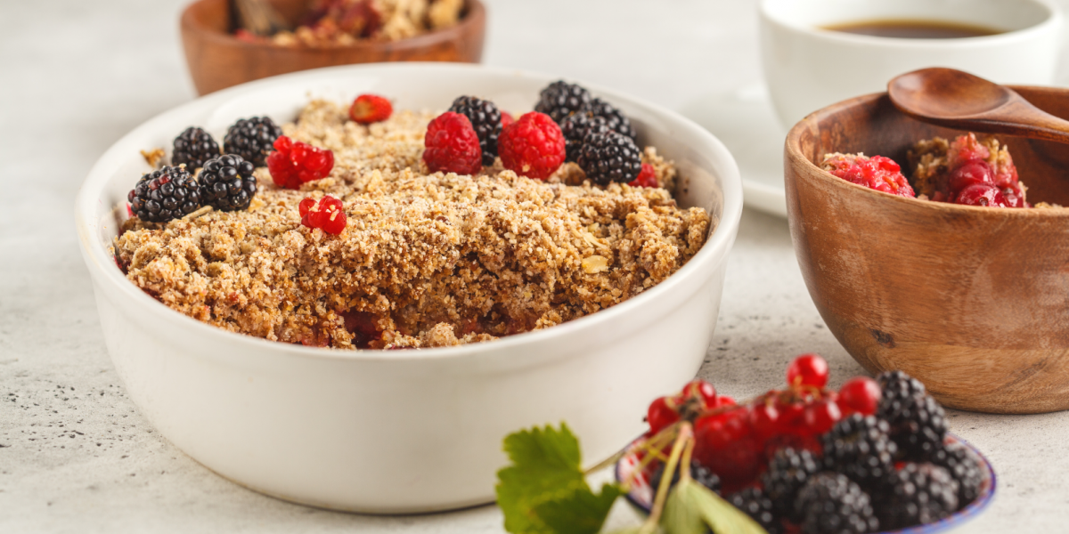 Banana Blueberry Oatmeal Bake Recipe Photo. Oatmeal and berry bake/crumble in white baking dish, against a mostly white background.