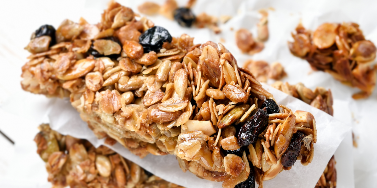 Recipe Photo for Cinnamon Oatmeal Breakfast Bars. A stack of home-cooked snack bars with raisins and oats, against a white background. 