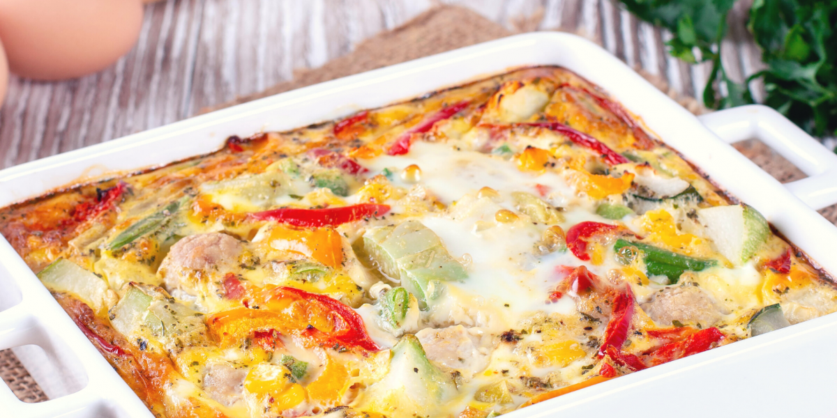 Hashbrown N' Peppers Casserole in a white baking dish, on a wooden counter.