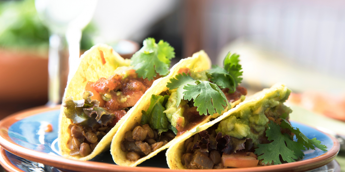 Lentil tacos on a plate, background of image is blurred.
