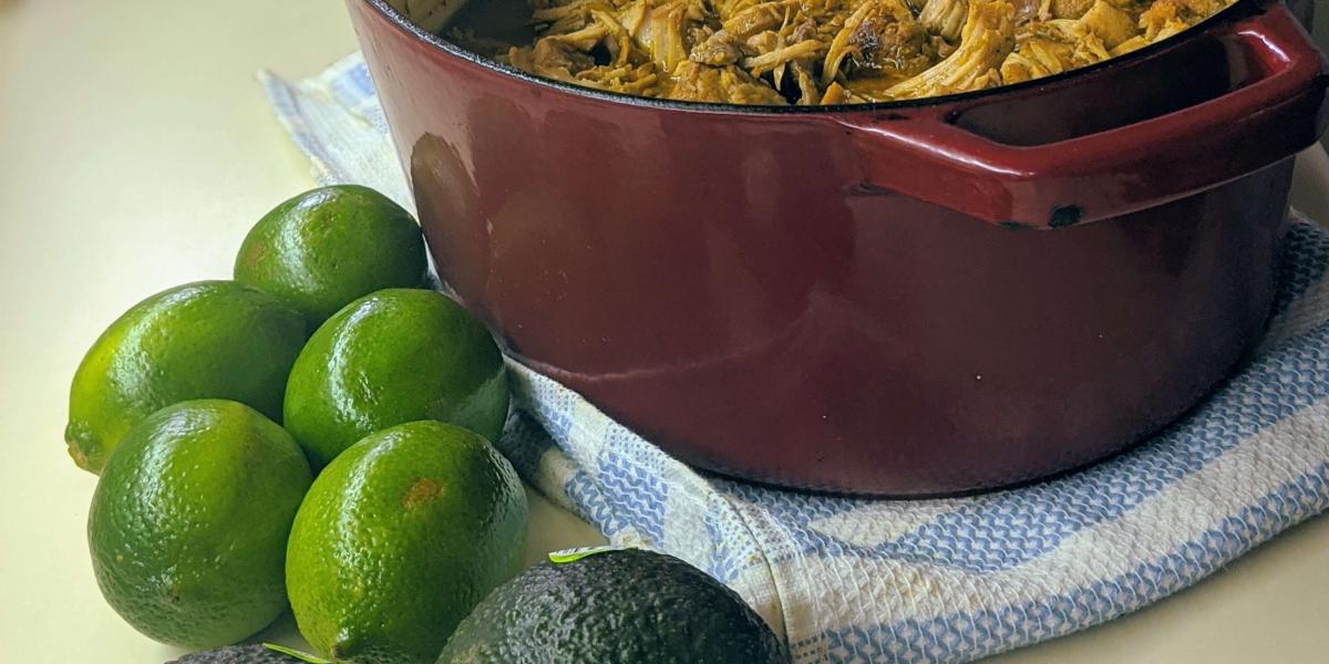 Slow Roasted Pork Loin in dutch oven with lime and avocado in front of the picture