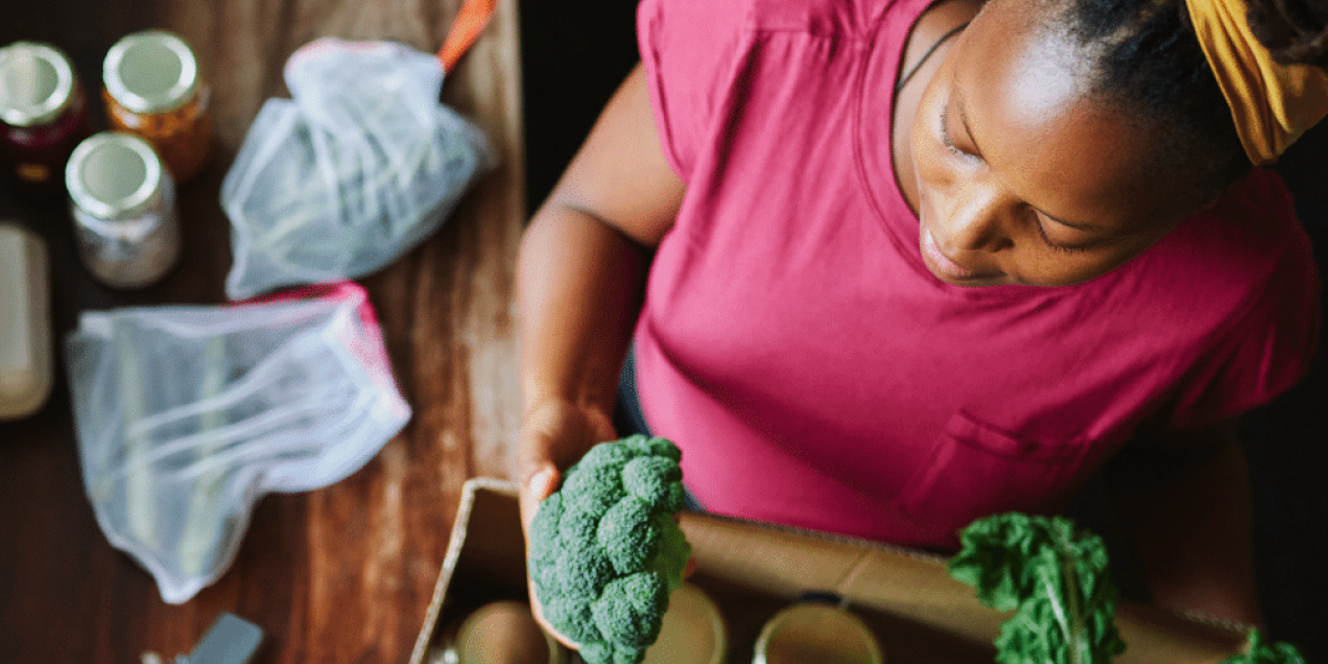 Woman with fresh vegetables and pantry staples at a food pantry