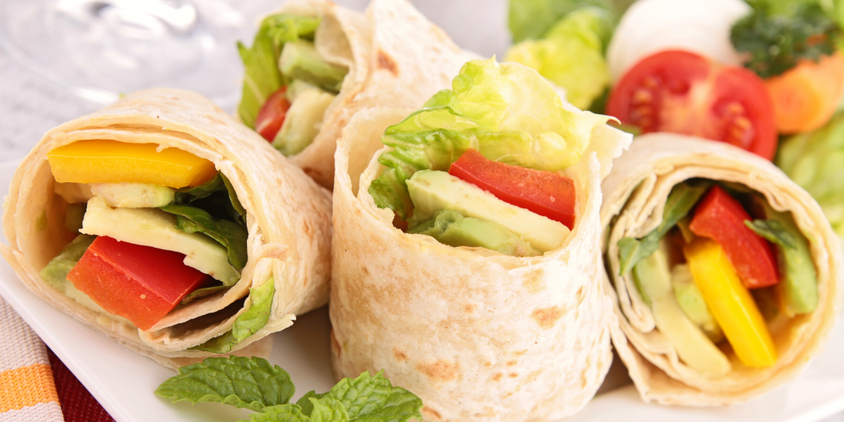 Closeup photo of small vegetable wraps on a white plate. 