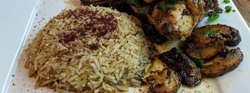 Lemon Herb Chicken with mushrooms and rice on white plate