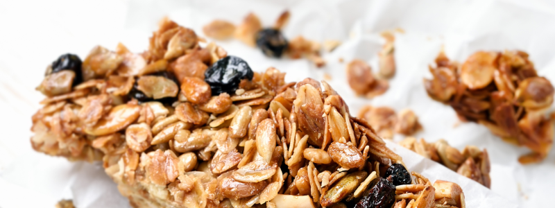 Recipe Photo for Cinnamon Oatmeal Breakfast Bars. A stack of home-cooked snack bars with raisins and oats, against a white background. 