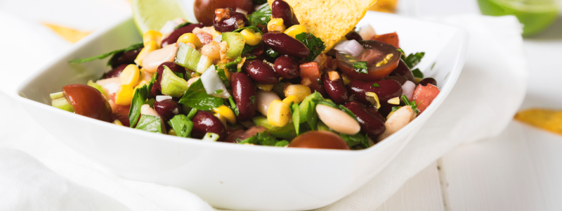 Cowboy Caviar with tortilla chips in white serving ware