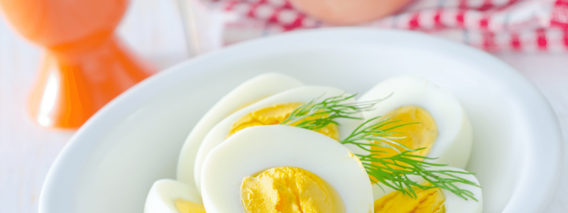 Hard boiled eggs cut in half in white bowl