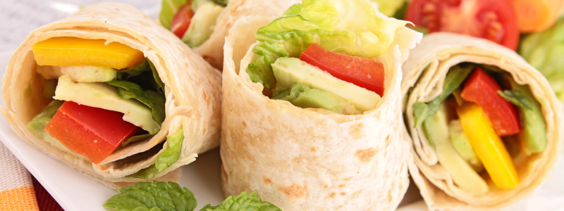Closeup photo of small vegetable wraps on a white plate. 