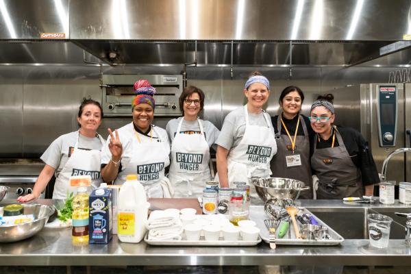 image of chefs and volunteers around a demo table in kitchen