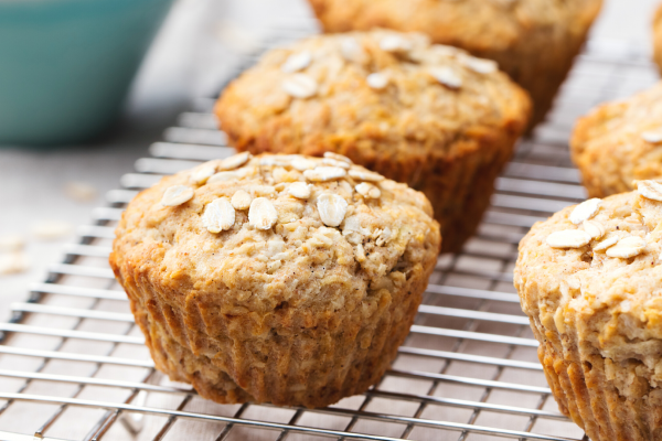 Photo of Apple Oatmeal Muffins on a metal cooling rack, with a blue bowl in the background.