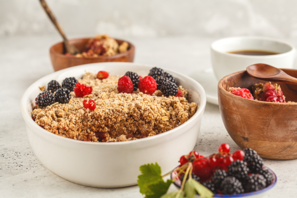 Banana Blueberry Oatmeal Bake Recipe Photo. Oatmeal and berry bake/crumble in white baking dish, against a mostly white background.