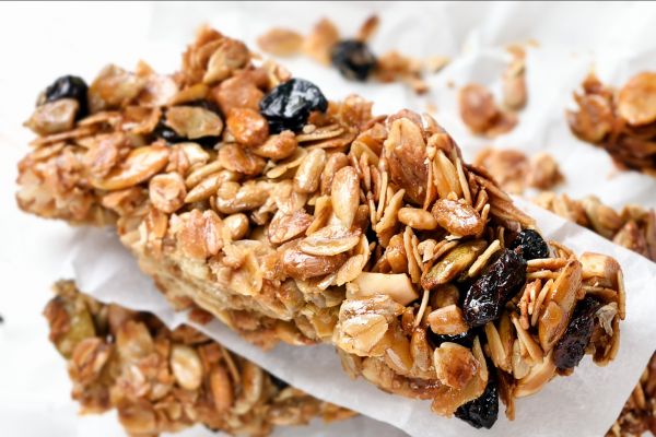 Recipe Photo for Cinnamon Oatmeal Breakfast Bars. A stack of home-cooked snack bars with raisins and oats, against a white background. 