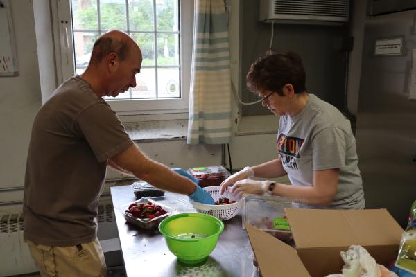 Glenn Geber and Linda Schurman wash fresh produce in the pantry