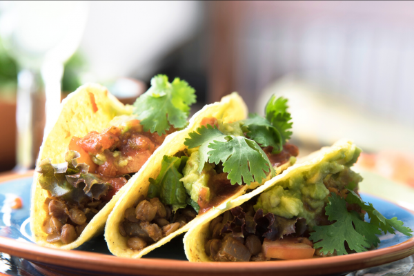 Lentil tacos on a plate, background of image is blurred.