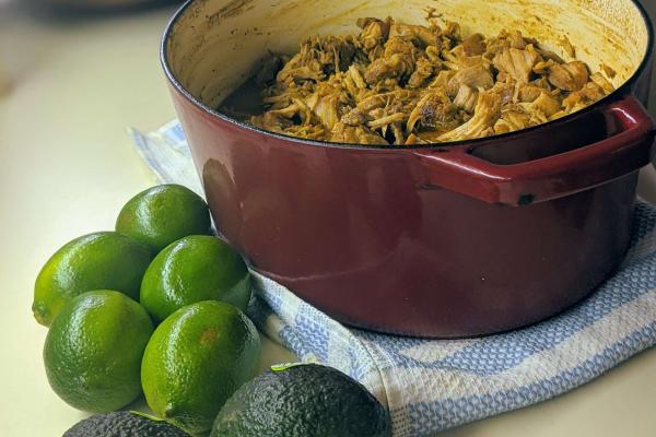 Slow Roasted Pork Loin in dutch oven with lime and avocado in front of the picture