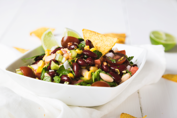 Cowboy Caviar with tortilla chips in white serving ware