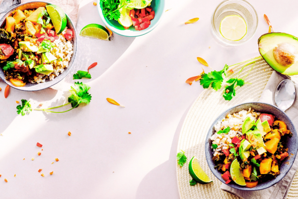 Healthy meal with avocados and cilantro, limes and lemons on the table and a table setting